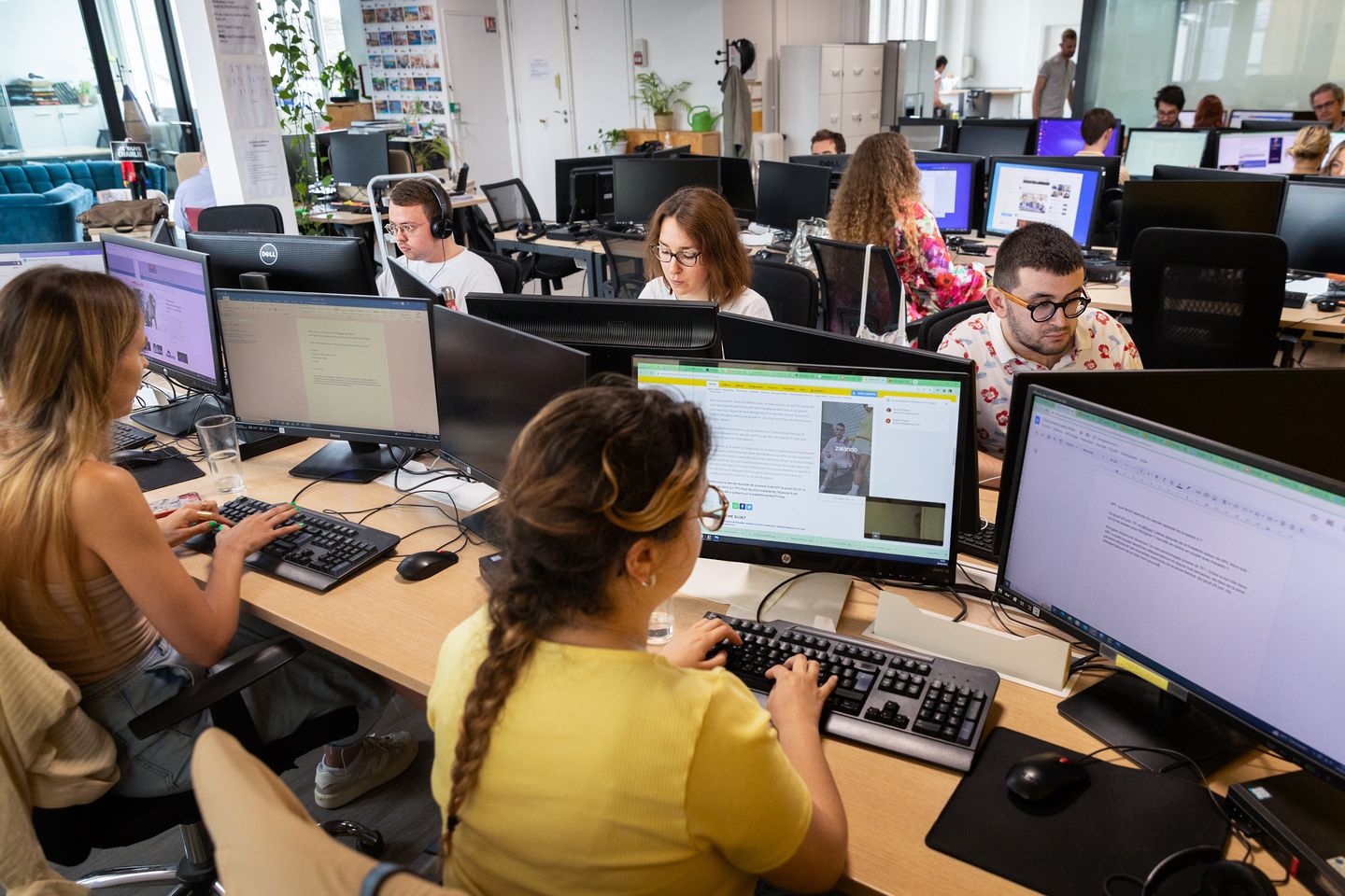 Le desk de 6Médias à Paris : des journalistes travaillent face à leurs écrans dans un open space lumineux.